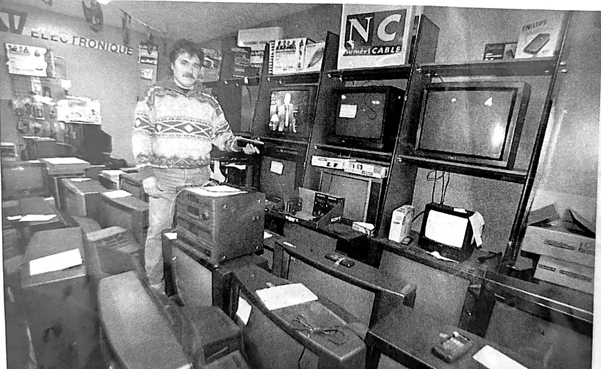 Photo de presse des années 2000 : l'atelier de réparation TV ASD Electronique à Perpignan avec les téléviseurs en cours de réparation