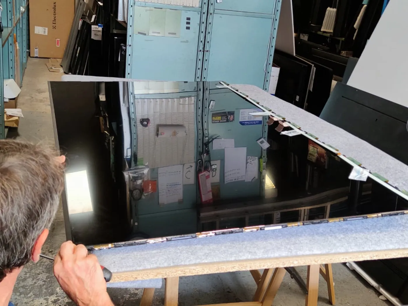 Réparateur TV à Perpignan : démontage de la dalle d'un téléviseur dans l'atelier ASD Electronique